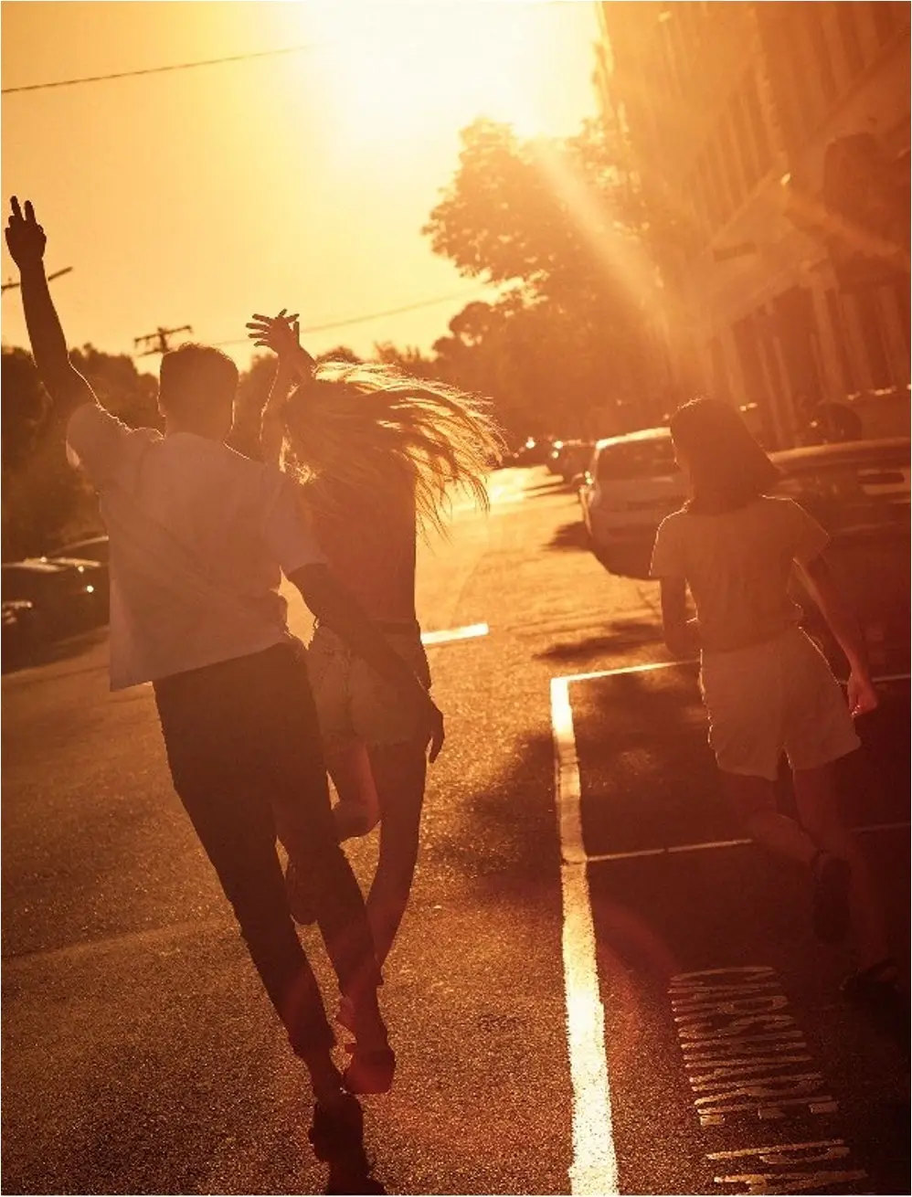 Friends running into a golden Always Summer sunset